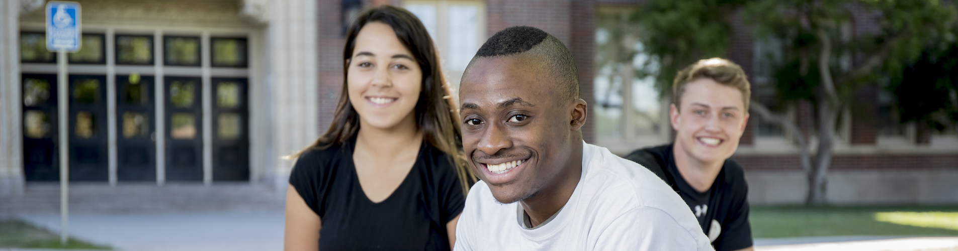 Three students in front of school